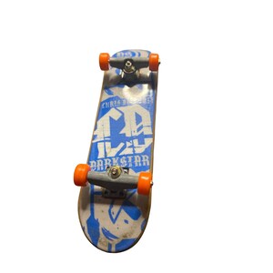 May include: A blue and white fingerboard skateboard with orange wheels. The board has the text "Chris Cole" and "Darkstar" printed on it.