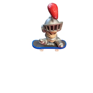 May include: A silver toy figure of a knight wearing a helmet with a red plume, riding a blue and white toy skateboard. The skateboard has the word "Tech Deck" printed on it.
