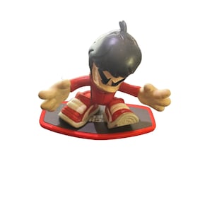 May include: A red and black action figure of a person riding a red skateboard. The figure has black hair and is wearing a red jumpsuit with white accents.