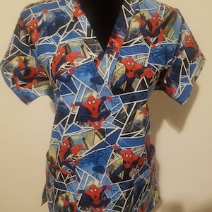 May include: A blue and red short-sleeved scrub top with a V-neck and a pattern of Spider-Man characters in a comic book style.