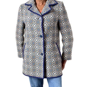 May include: A vintage coat with a geometric pattern in shades of blue, white, and tan. The coat has a notched collar, three buttons, and dark blue trim. The knee-length coat has long sleeves. The coat's trim and buttons are dark blue.