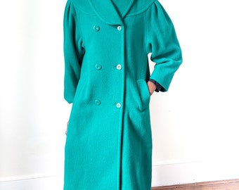 May include: A teal green double-breasted wool coat with a large collar.