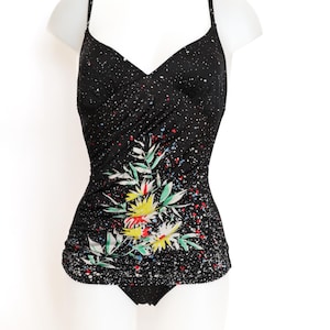 May include: Black swimsuit with a floral print and white polka dots. The floral print features yellow, red, and green flowers.