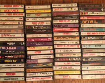 May include: A collection of vintage cassette tapes, stacked vertically in two rows. The tapes are a mix of different artists and genres, including hip hop, R&B, and pop. Some of the titles include "Ace Juice", "Queen Latifah", "The U-Krew", "Levert", "Krushin MC's", and "Chicago 18".