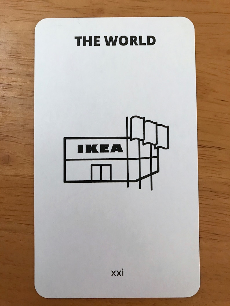 Puede incluir: Una tarjeta rectangular blanca con esquinas redondeadas que presenta el texto negro THE WORLD en la parte superior y el n&uacute;mero romano xxi en la parte inferior. En el centro hay un dibujo lineal negro de una tienda IKEA con tres banderas.