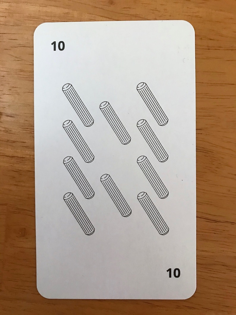 Puede incluir: Una carta de juego rectangular blanca con el n&uacute;mero 10 en las esquinas superior izquierda e inferior derecha. El centro de la carta muestra diez ilustraciones de l&iacute;neas negras de tacos cil&iacute;ndricos dispuestos en cuadr&iacute;cula.