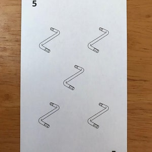 Puede incluir: Una carta de juego rectangular blanca con el n&uacute;mero 5 en las esquinas superior izquierda e inferior derecha. El centro de la carta muestra cinco ilustraciones de l&iacute;neas negras de llaves hexagonales en L dispuestas en patr&oacute;n de quincunce.