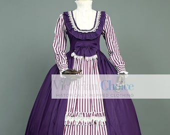 Op de afbeelding: Een Victoriaanse jurk in paarse en witte strepen, met een volle rok en lange mouwen. De jurk heeft een hoge halslijn met een witte kanten kraag en bies. Het lijfje is versierd met een strik en kanten details. De tekst "Victorian Choice" is zichtbaar.