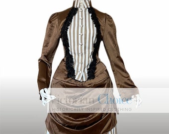 May include: A brown and white striped Victorian dress with a high collar and long sleeves. The bodice has a vertical striped pattern with black lace trim. The skirt features a striped pattern with a brown overskirt.