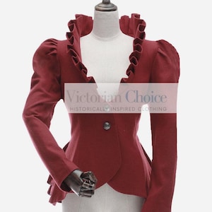 May include: A maroon fitted jacket with a ruffled collar and long sleeves. The jacket has a single button closure and a slightly pointed hem. The text "Victorian Choice" and "Historically Inspired Clothing" is printed on the jacket.