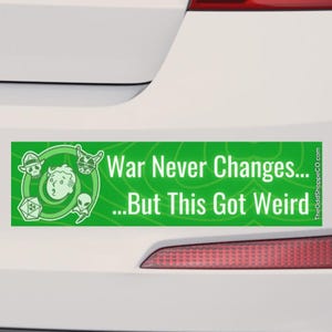 May include: A rectangular green bumper sticker featuring white text that reads War Never Changes... But This Got Weird. The design includes white line art illustrations of a skull, a cartoon face, a dog, an alien, and a radiation symbol.