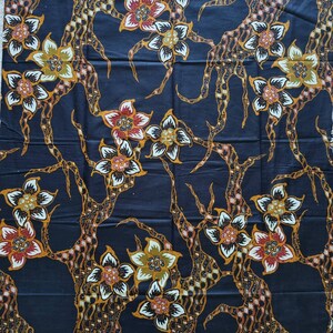 May include: Black fabric with a repeating pattern of stylized flowers in shades of orange, yellow, white, and red. The flowers are arranged on a dark blue background with a swirling, vine-like pattern.