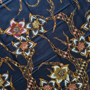 May include: Black fabric with a repeating pattern of stylized flowers in shades of orange, red, white, and green. The flowers are arranged on a dark blue background with intricate branches.