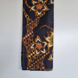 May include: Black fabric with a floral pattern in shades of orange, yellow, and white. The fabric features a repeating design of stylized flowers and leaves.
