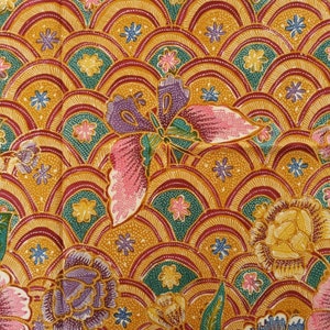 Peut inclure: Gros plan sur un tissu avec un motif répétitif de fleurs et de papillons colorés. Le fond est jaune doré avec des accents rouges et verts.