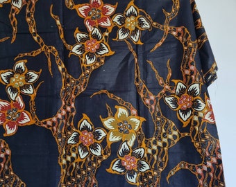 May include: Black fabric with a floral pattern in shades of orange, yellow, and red. The fabric features a repeating design of stylized flowers and branches.