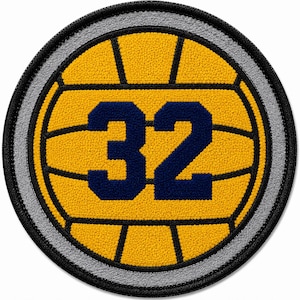 May include: A circular embroidered patch featuring a yellow water polo ball design with black lines and the dark blue number 32 centered in the middle. The patch has a thick black border and a thin grey inner ring, creating a textured appearance.