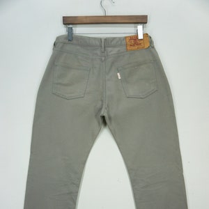 May include: A pair of light gray denim jeans with a red label on the back pocket. The jeans have a straight leg fit and are made of a soft, comfortable fabric.