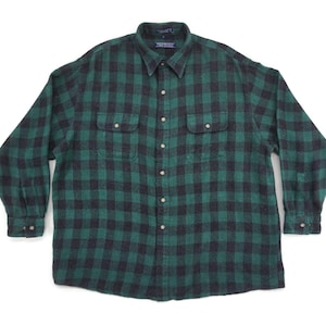 May include: A green and black plaid flannel shirt with a button-down collar and long sleeves. The shirt has two chest pockets with button closures.