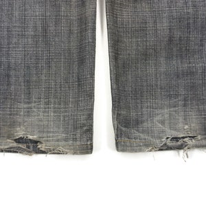 May include: A pair of dark grey denim jeans with frayed edges at the bottom.