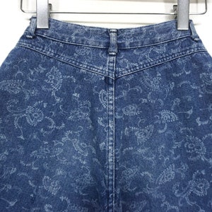 Puede incluir: Un par de pantalones cortos de mezclilla azul con un patr&oacute;n de paisley. Los pantalones cortos tienen cintura alta y cierre de bot&oacute;n.
