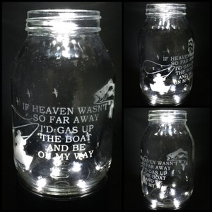 May include: A clear glass jar with a white etched design of a fisherman in a boat with a fish. The jar has a quote that reads "If heaven wasn't so far away I'd gas up the boat and be on my way".