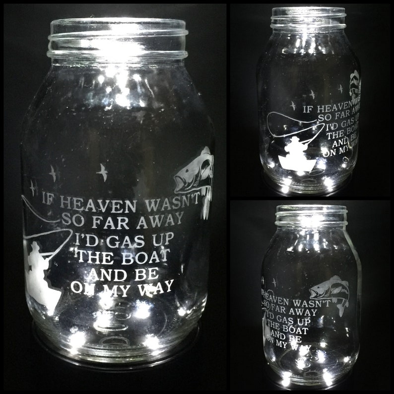 May include: A clear glass jar with a white etched design of a fisherman in a boat with a fish. The jar has a quote that reads "If heaven wasn't so far away I'd gas up the boat and be on my way".