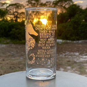 May include: A clear glass with a seahorse design and the text "Those we love don't go away. They walk beside us everyday. Not seen. Not heard. But always near... Still loved. Still missed. Forever dear."