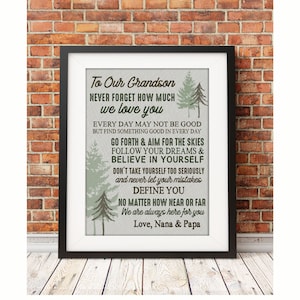 May include: A framed print with a light gray background and green trees. The print features a message to a grandson, encouraging him to follow his dreams and believe in himself. The text reads: "To Our Grandson Never Forget How Much We Love You Every Day May Not Be Good But Find Something Good In Every Day Go Forth & Aim For The Skies Follow Your Dreams & Believe In Yourself Don't Take Yourself Too Seriously And Never Let Your Mistakes Define You No Matter How Near Or Far We Are Always Here For You Love, Nana & Papa"