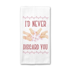 May include: White waffle-weave kitchen towel with the text "I'D NEVER DISCARD YOU" in red. The towel features a design of hands holding game tiles and small pink hearts. A decorative kitchen accessory.