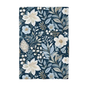 May include: A rectangular textile featuring a floral pattern. The design showcases large white and light blue flowers, along with smaller blossoms and leaves in shades of blue, beige, and white, set against a dark blue background.