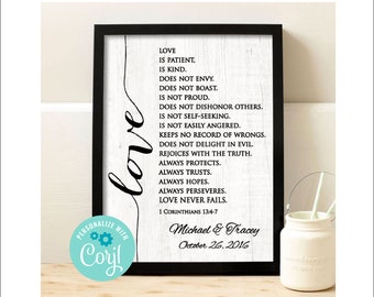 May include: A black framed print with a white background and black text. The text reads "Love is patient, is kind, does not envy, does not boast, is not proud, does not dishonor others, is not self-seeking, is not easily angered, keeps no record of wrongs, does not delight in evil, rejoices with the truth, always protects, always trusts, always hopes, always perseveres, love never fails. 1 Corinthians 13:4-7". Below the text is the name "Michael & Tracey" and the date "October 26, 2016".