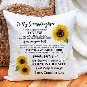 May include: White throw pillow with a sunflower design and the text "To My Granddaughter Never forget how much I LOVE YOU AS YOU GROW OLDER, you will face many challenges in life Just do your best LIFE ISN'T ABOUT WAITING FOR THE STORM TO PASS IT'S ABOUT LEARNING TO DANCE IN THE RAIN EVERY DAY MAY NOT BE GOOD BUT FIND SOMETHING GOOD IN EVERY DAY Laugh, Love, Live FOLLOW YOUR DREAMS & BELIEVE IN YOUR SELF I will always be with you Love, Grandma Rose"