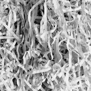 May include: A close-up of white shredded paper, commonly used as packing material for gifts and fragile items.