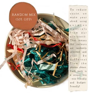 Op de afbeelding: Een kom gevuld met kleurrijk gescheurd papier in roze, rood, teal en goud. Een rond label leest "RANDOM MIX (50% OFF)". Tekst aan de rechterkant beschrijft het product als milieuvriendelijk en gemaakt van overtollige materialen.