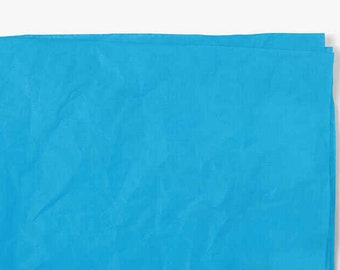 Pode incluir: Um pedaço de tecido azul claro, dobrado ao meio, com uma superfície lisa e ligeiramente texturizada.