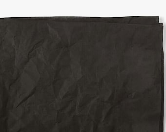 May include: A sheet of black tissue paper, crumpled and textured.