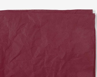 May include: A sheet of burgundy tissue paper, crumpled and folded, with a smooth, even texture.