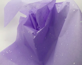 May include: Purple tissue paper with silver glitter. The tissue paper is crumpled and folded.