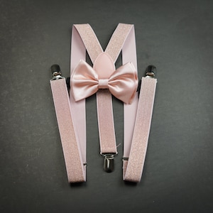 Puede incluir: Tirantes y pajarita a juego de color rosa. Los tirantes tienen un acabado brillante y la pajarita es de satén.