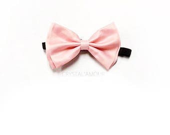 May include: A pink bow tie with a black elastic band.