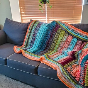 Crochet blanket in peaches, lime greens, reds, grays, oranges, light blues and teals