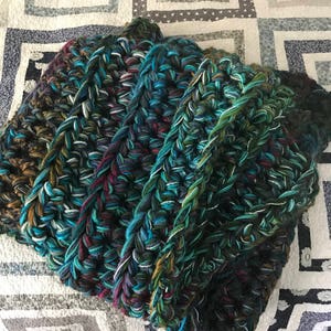 Crochet blanket in teal, blue, green, magenta and grey