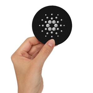 Op de afbeelding: Een ronde zwarte patch met een wit geborduurd logo van een cirkel met meerdere kleinere cirkels eromheen.