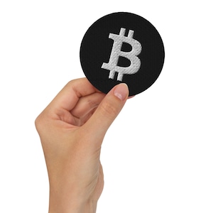 May include: A black fabric patch with a white embroidered Bitcoin symbol.