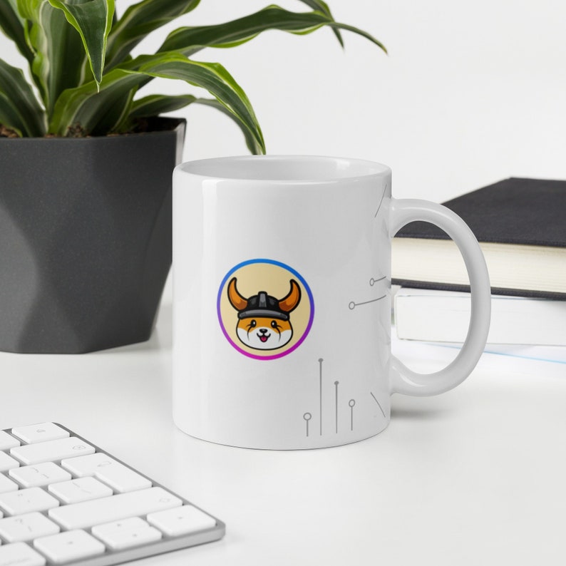 Pu&ograve; includere: Tazza in ceramica bianca con un'immagine di un cartone animato di una volpe che indossa un casco e un design circolare giallo, arancione, viola e blu. La tazza ha un manico bianco e uno sfondo bianco con un design a circuito grigio.