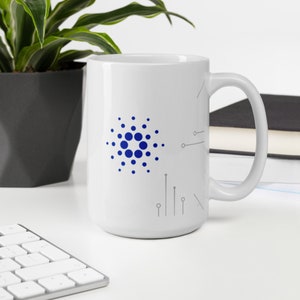 May include: White ceramic mug with a blue and gray design featuring a stylized circle with dots and lines. The mug has a handle on the right side.
