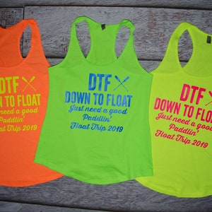 May include: Three neon tank tops with the text "DTF DOWN TO FLOAT" and "Just need a good Paddlin' Float Trip 2019". The tank tops are in orange, green, and yellow.