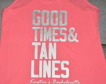 May include: A neon coral racerback tank top featuring the silver block-lettered text GOOD TIMES & TAN LINES and the script text Kristin's Bachelorette printed on the front. The garment has a scoop neckline and a sleeveless design.