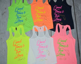 May include: A collection of six racerback tank tops in various bright colors, including neon green, orange, white, pink, and navy. Each tank top features the text "Good Times & Tan Lines" with a Florida outline and "Miami, FL" in a script font.